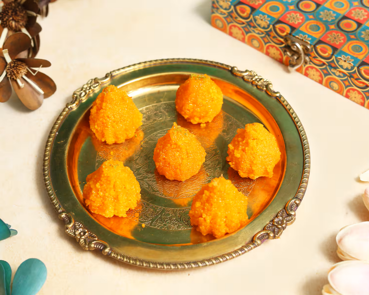 Nutty Ghee Sweets motichoor modak in Gurgaon six bright orange traditional Indian sweet dumplings on a brass plate