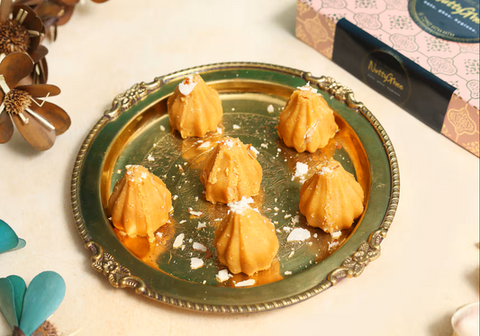 Rewari Modak in Gurgaon displayed on a brass plate six ghee sweets sprinkled with nuts by Nutty Ghee Sweets
